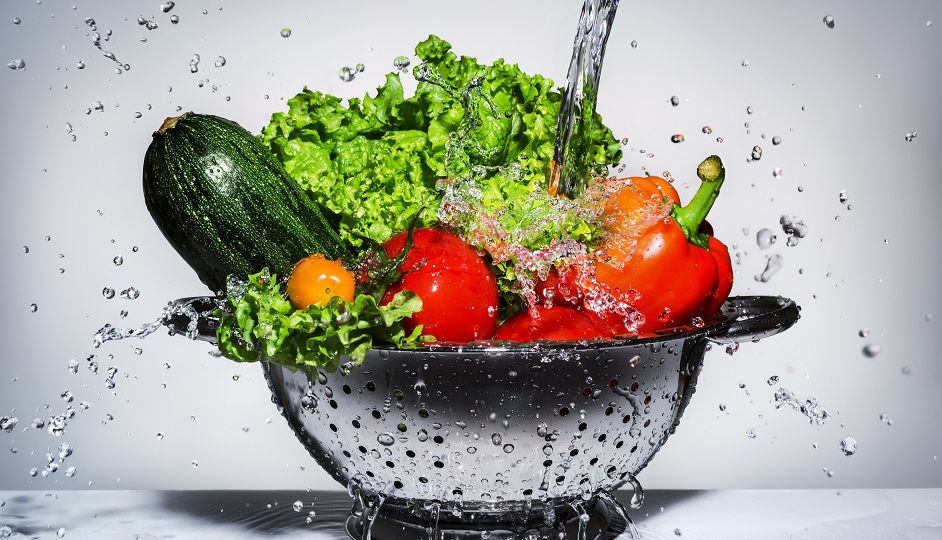 vegetables in a colander under running water