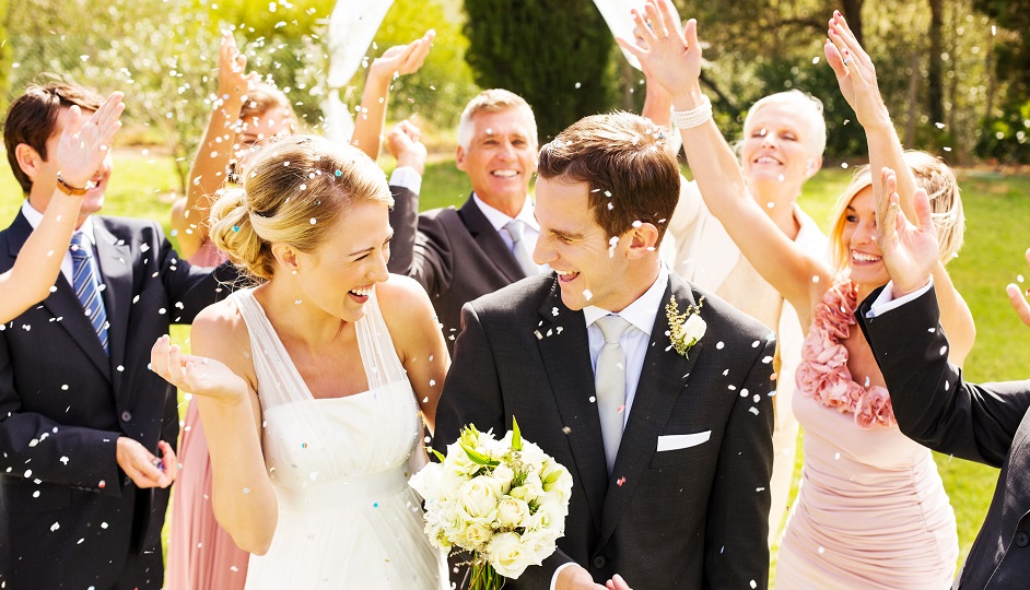 Guests Throwing Confetti On Couple During Reception In Garden