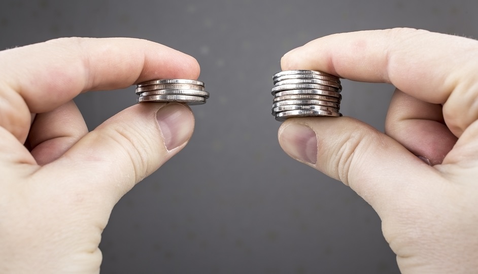 Hands compare two piles of coins of different sizes